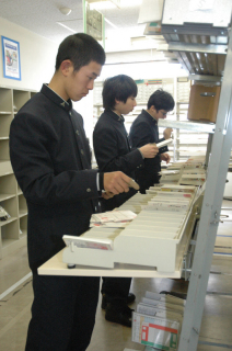 年賀状の仕分け作業に精を出す高校生アルバイト＝26日、鶴岡郵便局