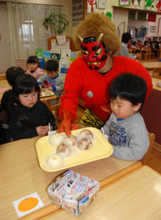 「鬼のまんじゅう屋さん」が園児たちに作りたてホカホカのへそまんじゅうをプレゼント