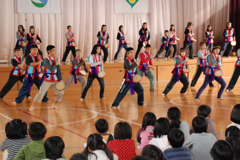 今帰仁村の子供たちが沖縄の伝統芸能「エイサー」を元気いっぱいに披露した＝8日午後、酒田市の泉小