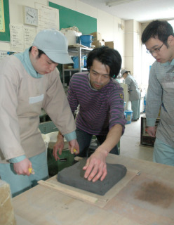 中村さん（中央）から陶芸技術を学ぶ鶴高養窯業班の生徒たち