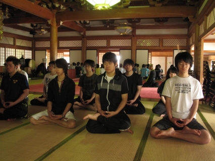 背筋を伸ばして座禅を組む公益大の学生たち＝15日、鶴岡市の善寳寺