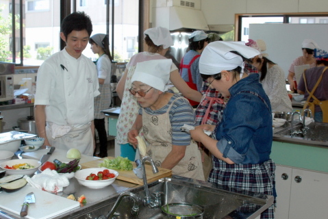 太田シェフ（左）の指導で調理法を学ぶ女性たち