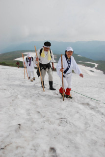 雪渓を踏みしめ、参拝者たちが思い思いのペースで山頂を目指した＝1日午前