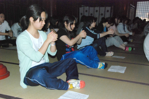 三神合祭殿で「鎮魂」行に挑戦する公益大の学生たち＝29日夜