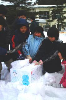 鹿児島県の笠木小へプレゼントする雪を詰める福栄小の児童たち