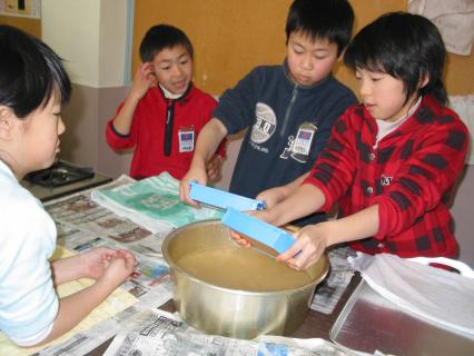 ケナフの繊維ではがきをすく余目三小の子供たち