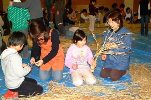 酒田女鶴の稲わらで、一輪挿しづくりに取り組む琢成小の親子