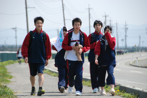 友達と励まし合いながらゴールを目指す鶴南山添校の生徒たち＝鶴岡市白山付近