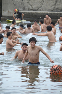 恒例の水開きでまだ冷たい海へ入る加茂水高の生徒たち