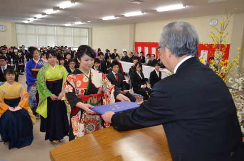 齋藤校長（右）から卒業証書を受け、決意を新たにする卒業生