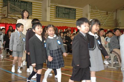 在校生や保護者たちの拍手に迎えられ、入場する新入生たち＝鶴岡市の大山小