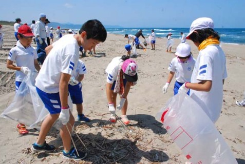 海岸に落ちているごみを拾う浜中小の子供たち