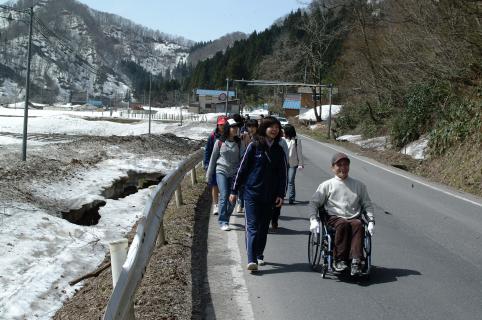 雪が残る山間の春の景色を楽しみながらゴールを目指す参加者たち