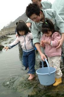 加茂水産高の生徒と由良保育園の園児が一緒にハタハタの稚魚を放流