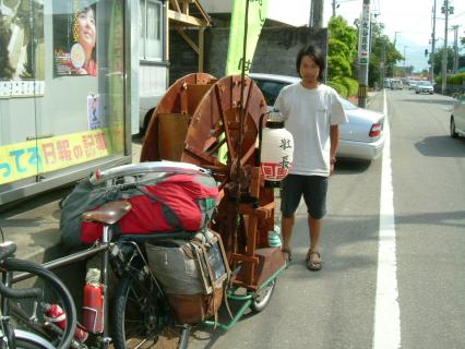 自転車の後ろに手製の水車型トレーラーを積み、全国行脚中の土居さん