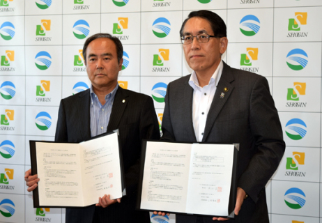 調印式で協定書を交わす上野頭取（左）と丸山市長