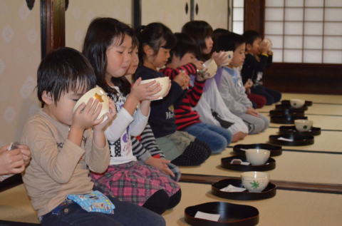 自分の顔と同じくらいの茶わんでお茶を飲む園児たち