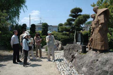 藤沢周平ゆかりの地を訪ねて説明を聞く市民たち＝鶴岡市総穏寺