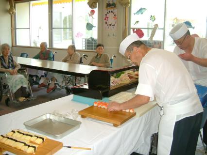 お年寄りたちの前で腕を振るう川上さん