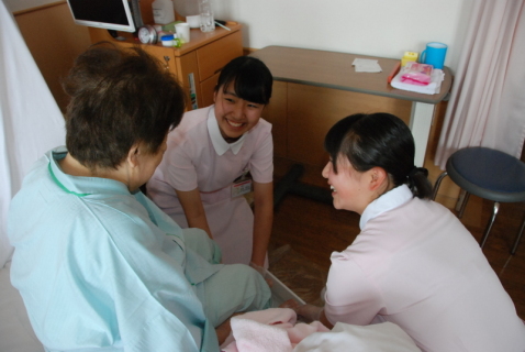 笑顔で会話しながら看護業務を体験する高校生たち