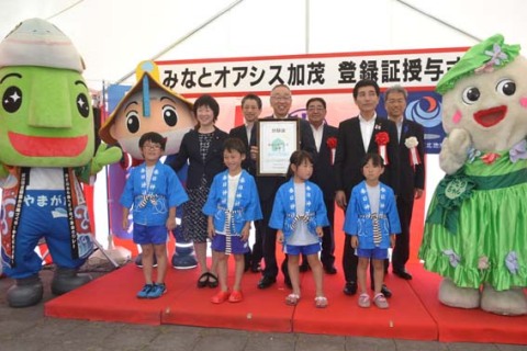 みなとオアシス加茂の登録証が鶴岡市に授与され、関係者が笑顔で記念撮影