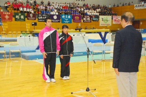 体操競技の開会式で山口部長（右）に向かい、選手宣誓する亀山さん（奥左）と桑原さん（同右）＝1日、酒田市国体記念体育