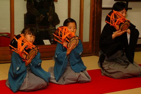 プロの能楽師とともに小鼓の演奏を発表する小学生たち