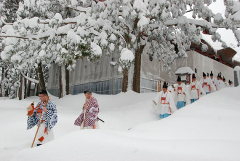 雪深い羽黒山頂で松例祭で使われた五穀のもみを背負って蜂子神社に向かう既修松聖ら。蜂子神社で明治から約150年ぶりに「春の峰」の勤行が復活した