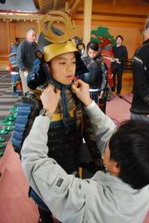 甲冑の着付けを体験する志布志市の子どもたち＝19日、松山城址館