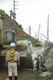 通行止めの解除に向けた作業が進む鶴岡市小岩川の土砂崩れ現場＝15日午前