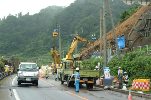 鶴岡市小岩川の土砂崩れ現場でＪＲによる応急工事と酒田河川国道事務所の防護柵の設置工事がスタートした＝１７日午前