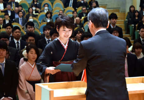吉村学長（右）から卒業証書を受ける学部卒業生総代の大沼さん