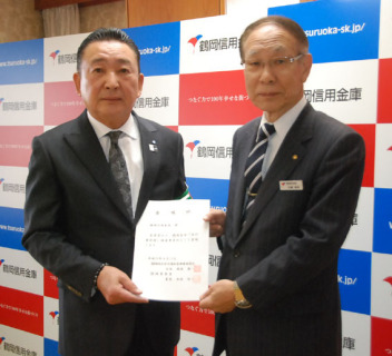 難波会長（左）から鶴岡信用金庫の加藤会長へ委嘱状が交付された