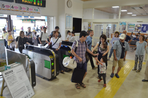 大きな荷物を手にした帰省客でにぎわうＪＲ鶴岡駅。再会を喜ぶ姿が見られた