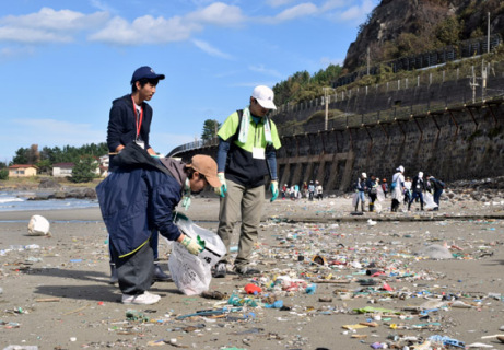 公益大生らによる「ＳＣＯＰ遊佐」が開幕。釜磯海岸でごみを拾い集める参加学生たち＝13日午前