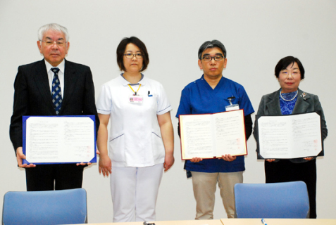 調印後に協定書を披露。左から栗谷理事長、上野さん、太田院長、井上会長