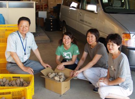 ゴドイモをもらって大喜びの保育士ら（右3人）。左は協力隊メンバーの高橋さん＝16日