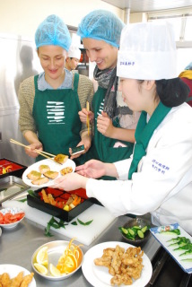酒調の学生（右）と一緒に、楽しそうに弁当作りに取り組む食科学大の学生たち