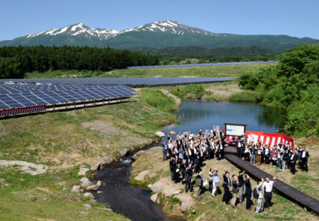 遊佐町吉出地区に完成、稼働している「庄内・遊佐太陽光発電所」。見学会に訪れた人たちが記念撮影