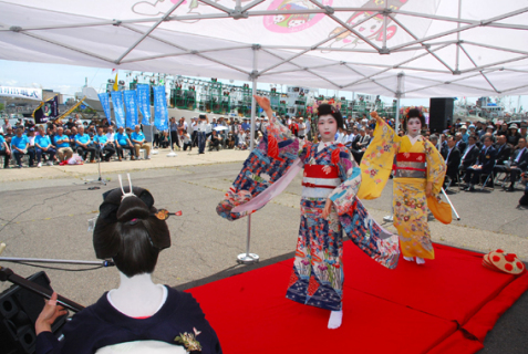 乗組員たち（左奥）に酒田舞娘が踊りを披露し、花を添えた出航式