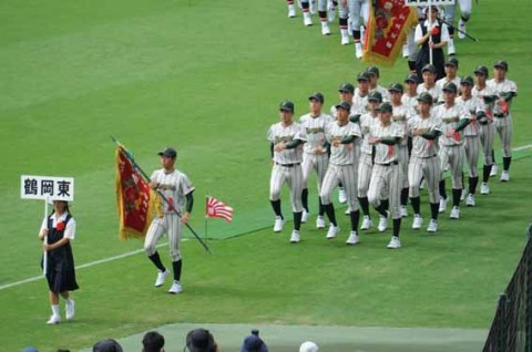新たな歴史を刻む101回目の開会式で、堂々と行進する鶴岡東ナイン＝6日、阪神甲子園球場