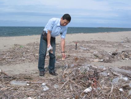 30日に調査を予定する酒田市宮野浦海岸で、海洋ごみについて説明する金子さん＝5日