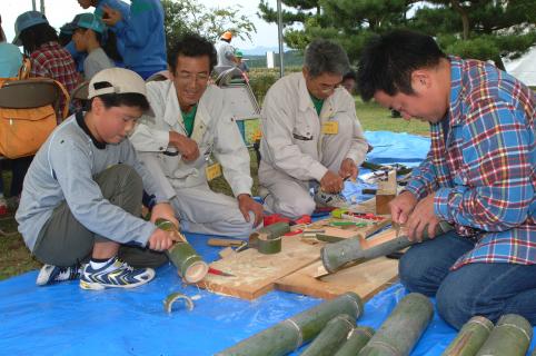 「それ、頑張れ。引く時に力を入れて」。森の達人たちからアドバイスを受け、丸太切りに挑戦