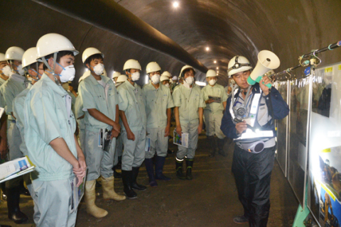 工事請負業者から説明を受けながら日沿道・大岩川トンネルの建設現場を見学する鶴岡工業高の生徒たち