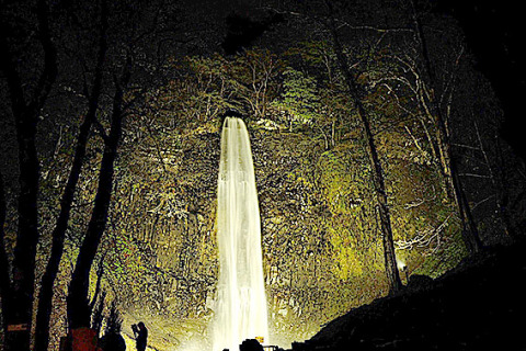 ライトアップで淡く浮かび上がる玉簾の滝＝30日夜