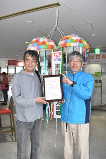 浦さん（左）に奥泉館長から400万人記念の認定書が贈られた