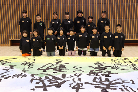 三川町民体育館で書道パフォーマンスを披露する大瀧習字教室の子どもたち＝22日、テオトルで行われた練習会