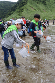 森を背景に砂浜ではヒラメの稚魚の放流も行われた