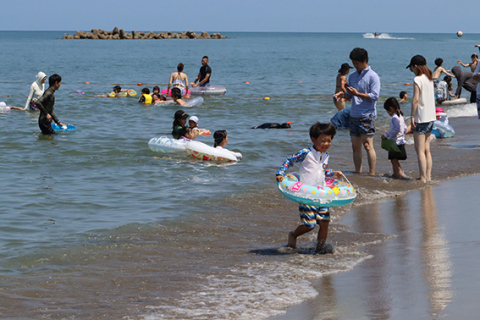 梅雨明けとなった22日、大勢の家族連れが海水浴に繰り出し、海辺に歓声が響いた＝鶴岡市・湯野浜海水浴場