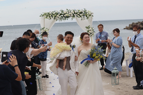 海と砂浜を舞台にした「夢婚」。文平さんと愛さん、世菜海ちゃんを花びらの「フラワーシャワー」で祝福した